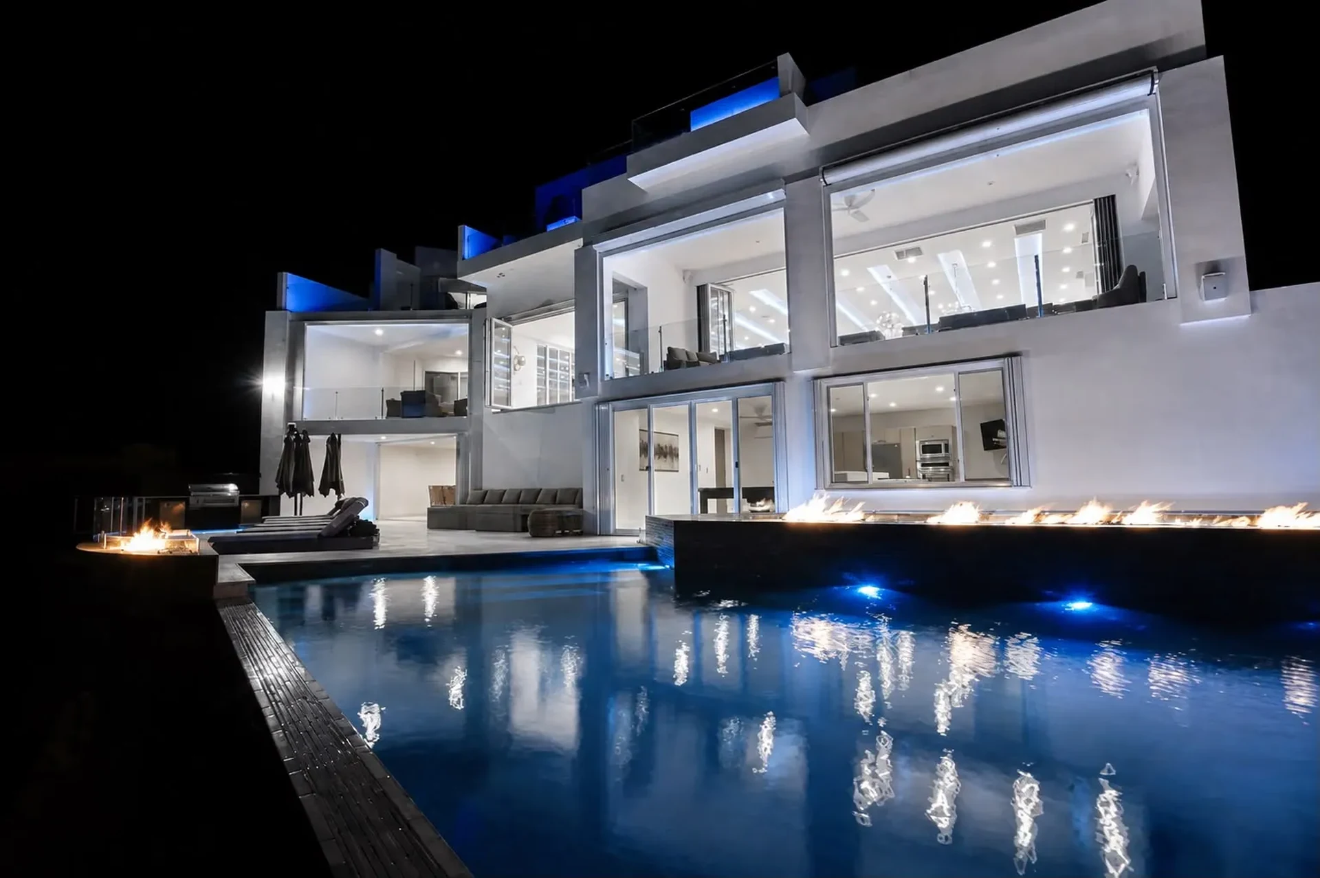 Villa Lands End modern white villa and infinity pool lit at night in Cabo San Lucas